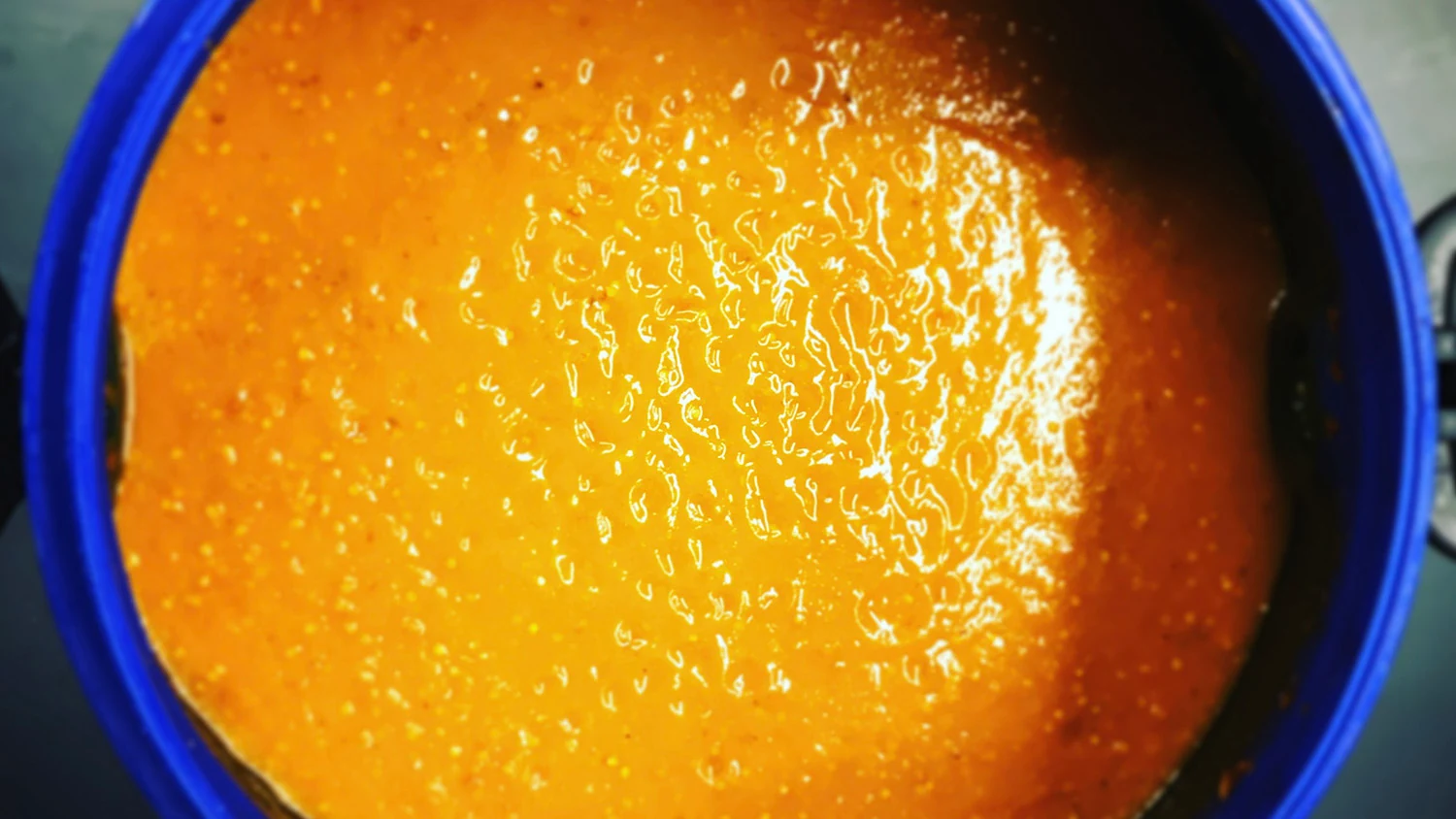 Fresh chilli mash beginning its natural fermentation process in a barrel